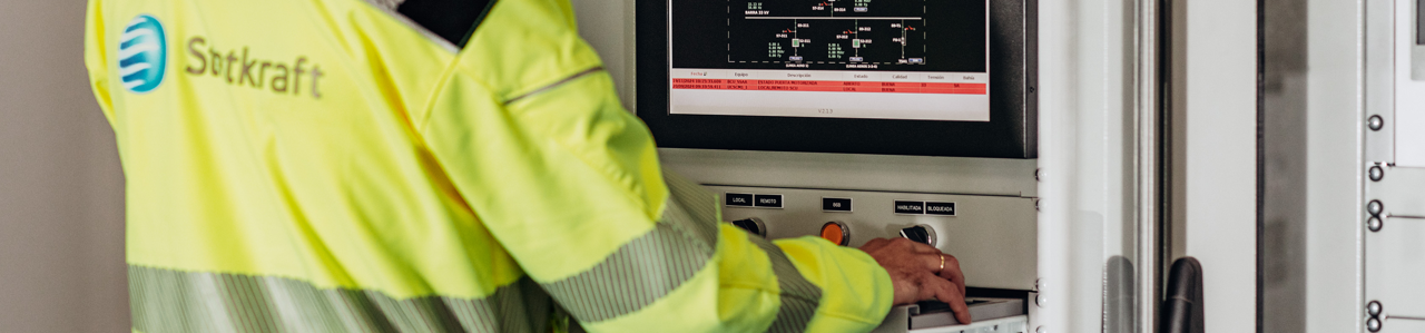Worker in PPE using equipment with a screen