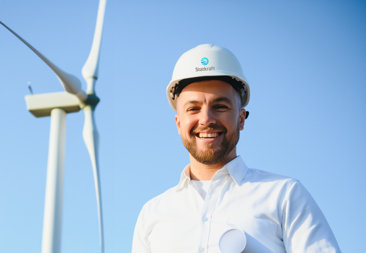 Engineer standing in front of a wind turbine
