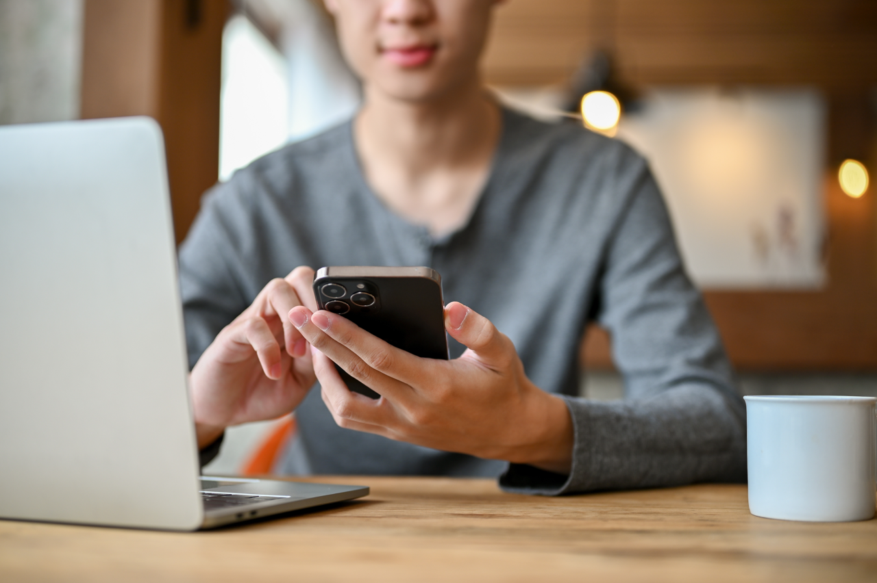 Man sitting at desk with laptop and phone