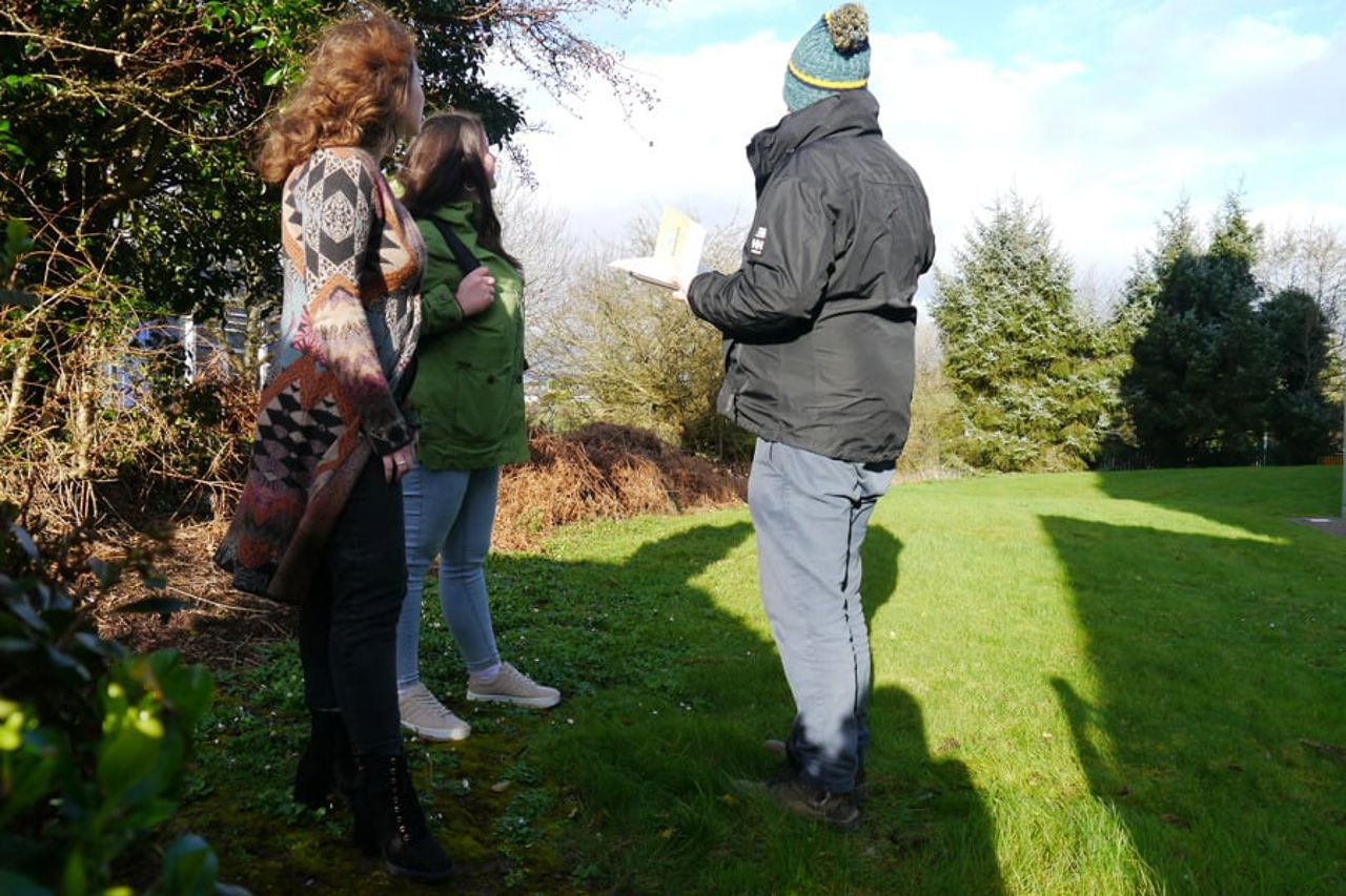 3 people speaking outside in woodland area