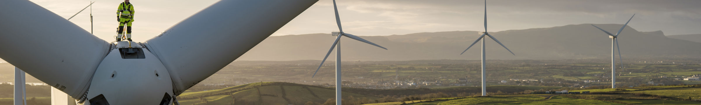 Statkraft engineer on top of turbine in Acres at dusk